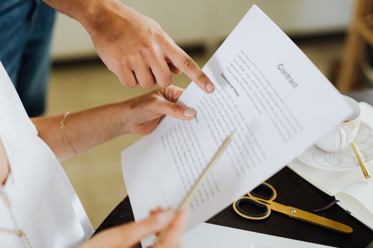 Crafting Captivating Headlines: Your awesome post title goes here Close-up of two people discussing a business contract at a desk in an office setting.